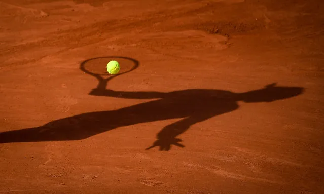 The shadow of Spain's Rafael Nadal is pictured as heA returns the ball to Britain's Cameron Norrie during their men's singles third round tennis match on Day 7 of The Roland Garros 2021 French Open tennis tournament in Paris on June 5, 2021. (Photo by Christophe Archambault/AFP Photo)