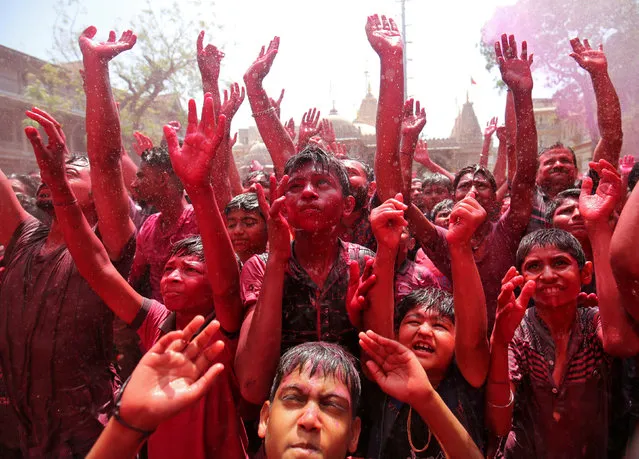 Hindu devotees raise their hands daubed in colours as they pray on a temple premises during Holi celebrations in Ahmedabad, India, March 20, 2019. (Photo by Amit Dave/Reuters)