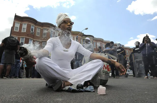 Shawna Murray-Browne sits in a street in Baltimore, Tuesday, April 28, 2015. Maryland's governor vowed there would be no repeat of the looting, arson and vandalism that erupted Monday in some of the city's poorest neighborhoods. (Photo by Lloyd Fox/The Baltimore Sun via AP Photo)