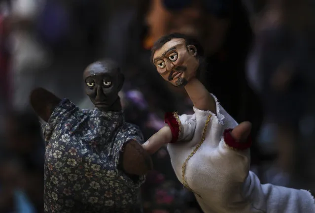 In this March 24, 2019 photo, a puppeteer presents his hand puppets during an event at the National Culture Museum in Mexico City. The event was held in honor of World Puppetry Day, observed earlier in the week on March 21. (Photo by Marco Ugarte/AP Photo)