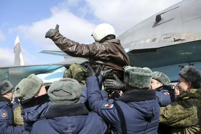 A Russian military pilot is greeted upon his return from Syria to a home airbase during a welcoming ceremony in Buturlinovka in Voronezh region, Russia March 15, 2016. (Photo by Vadim Grishankin/Reuters/Russian Ministry of Defence)
