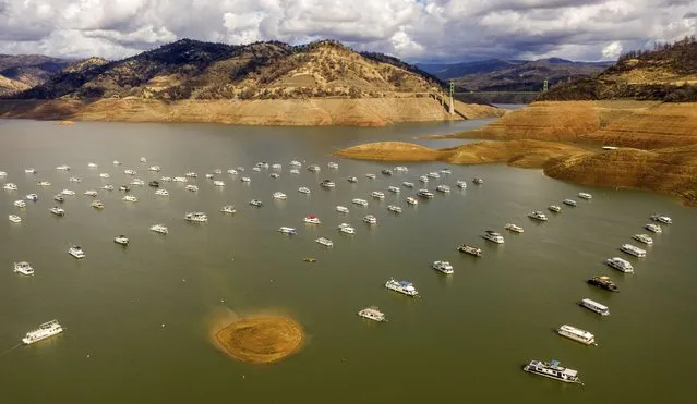 Houseboats float on Lake Oroville, Monday, October 25, 2021, in Oroville, Calif. Recent storms raised the reservoir more than 16 feet, according to the California Department of Water Resources. (Photo by Noah Berger/AP Photo)