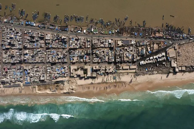 In this drone image, houses lay between the Senegal river, top, and the Atlantic Ocean beach that has been affected by erosion in Saint Louis, Senegal, Wednesday, November 3, 2021. World leaders are gathered in Scotland at a United Nations climate summit, known as COP26, to push nations to ratchet up their efforts to curb climate change. Experts say the amount of energy unleashed by planetary warming would melt much of the planet's ice, raise global sea levels and greatly increase the likelihood and extreme weather events. (Photo by Leo Correa/AP Photo)