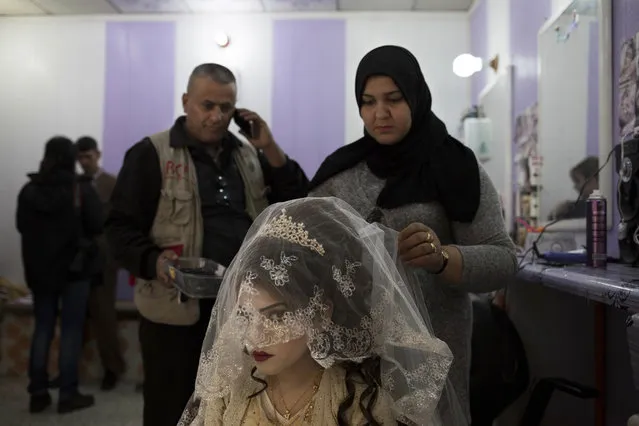 Shahad Ahmed Abed, 16, gets her hair done in a hair salon in Khazer for the wedding on Thursday, February 16, 2017. Abed and her husband Hussein Zeino Danoon both fled from Mosul within the last month, just as Iraqi forces pushed Islamic State militants out of the eastern side of the city. (Photo by Bram Janssen/AP Photo)