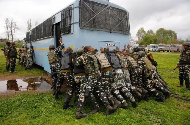 Indian paramilitary soldiers push their bus that was caught in mud at a polling equipment distribution center in Srinagar, Kashmir, India, 17 April 2019. The elections for Srinagar parliament constituency are scheduled to be held on 18 April 2019. The parliament elections which began on 11 April 2019 are to be conducted in seven phases throughout India. (Photo by Farooq Khan/EPA/EFE)