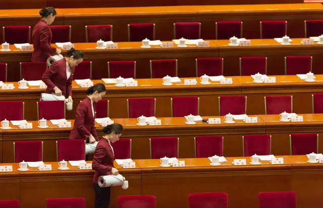 Attendants pour water for tea at the opening session of the National Peoples Congress (NPC) in the Great Hall of the People in Beijing, China, 05 March 2014. The NPC has over 3,000 delegates and is the world's largest parliament or legislative assembly though its function is largely as a formal seal of approval for the policies fixed by the leaders of the Chinese Communist Party. (Photo by Adrian Bradshaw/EPA)