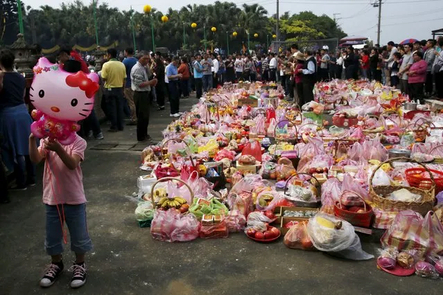 A child holds a Hello Kitty balloon as thousands of people surnamed Yeh attend an annual worship ceremony to pay respect to their ancestors on Qingming Festival, also known as Tomb Sweeping Day, in Taoyuan, Taiwan April 4, 2016. (Photo by Tyrone Siu/Reuters)