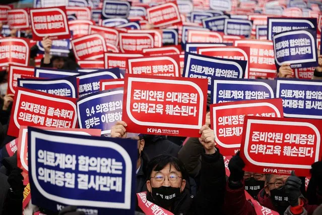 Doctors chant slogans during a rally to protest against government plans to increase medical school admissions in Seoul, South Korea, March 3, 2024. The banners read “Oppose increasing medical school admissions without talks with the medical community” (in blue) and “Medical education will be harmed in increasing medical school admissions” (in red). (Photo by Kim Hong-Ji/Reuters)