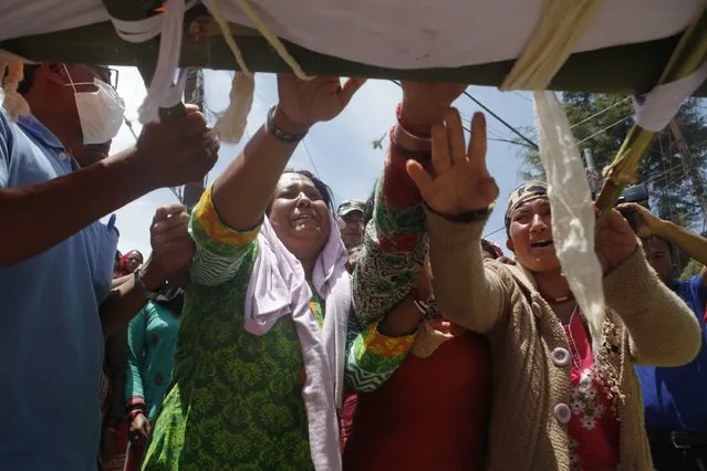 Relatives cry as the dead body of an earthquake victim is taken for cremation at Charikot, the administrative center of the hardly hit Dolakha district, Nepal, Thursday, May 14, 2015. (Photo by Niranjan Shrestha/AP Photo)