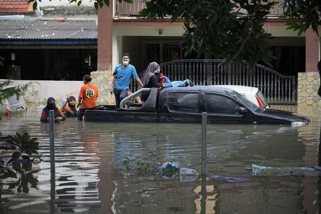 Residents are trapped at their house as a road was flooded in Shah Alam, on the outskirts of Kuala Lumpur, Malaysia, Monday, December 20, 2021. Rescue services on Monday worked to free thousands of people trapped by Malaysia's worst flooding in years after heavy rains stopped following more than three days of torrential downpours in the capital and around the country. (Photo by Vincent Thian/AP Photo)