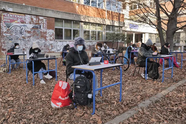 Students sit at desks outside a high school during a peaceful protest asking authorities to allow them back in to the classroom in Bergamo, Italy on January 19, 2021. (Photo by Luca Ponti/Pacific Press/Rex Features/Shutterstock)