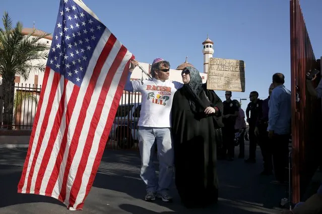 Two demonstrators stand in front of the Islamic Community Center to oppose the "Freedom of Speech Rally Round II" across the street in Phoenix, Arizona May 29, 2015. Arizona police stepped up security near a mosque on Friday ahead of a planned anti-Islam demonstration featuring displays of cartoons of the Prophet Mohammad, weeks after a similar contest in Texas came under attack from two gunmen.  REUTERS/Nancy Wiechec      TPX IMAGES OF THE DAY     