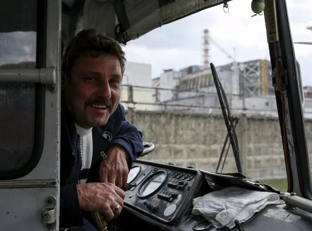 A bus driver smiles near a sarcophagus covering the damaged fourth reactor is seen at the Chernobyl nuclear power plant, Ukraine April 22, 2016. (Photo by Gleb Garanich/Reuters)