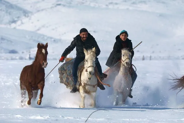 Young people ride their horses at snow covered path as they prepare their horses for the summer races in Toklular village of Bingol, Turkiye on January 09, 2022. (Photo by Aydin Arik/Anadolu Agency via Getty Images)