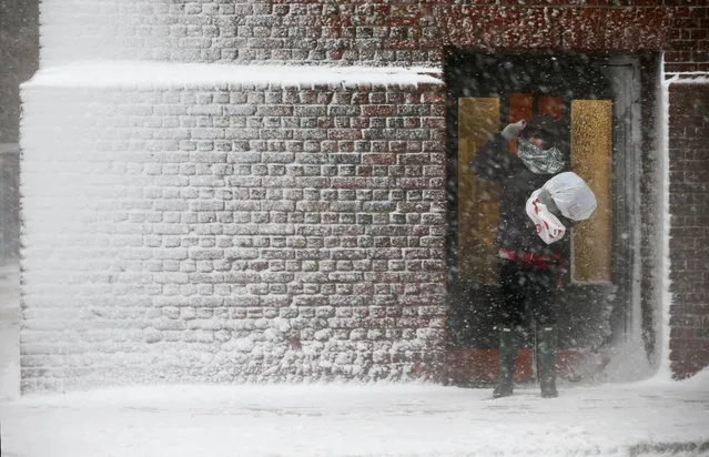 A person stands in the wind-driven snow during a winter storm Tuesday, March 14, 2017, in Boston. A powerful nor'easter hit the Northeast on Tuesday after a largely uneventful winter, dropping up to 2 feet of snow in some places, grounding thousands of flights and leading to school and work closures along the coast. (Photo by Michael Dwyer/AP Photo)