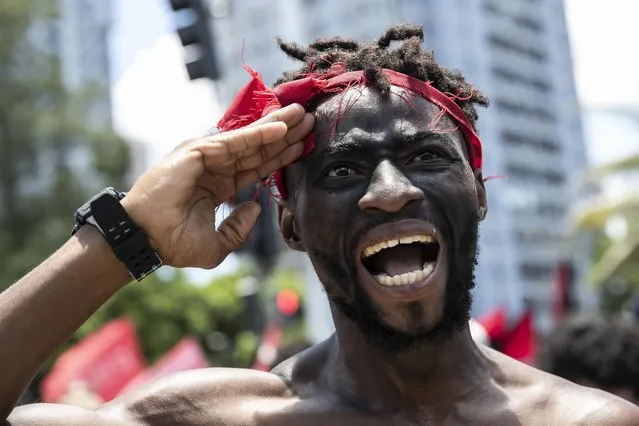 A friend of 24-year-old Congolese immigrant Moïse Mugenyi Kabagambe, takes part in a protest to demand justice for his violent death, at Barra da Tijuca beach, in Rio de Janeiro, Brazil, Saturday, February 5, 2022. The assailants were caught on security camera footage attacking the young man on Jan. 24, holding him down and beating him with a rod. (Photo by Bruna Prado/AP Photo)