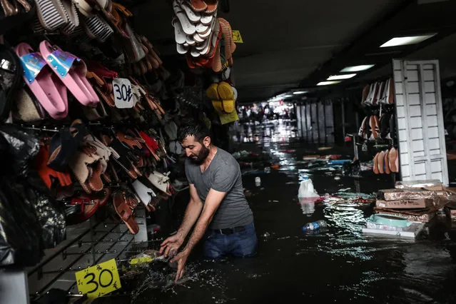 Sellers try to rescue their products as sellers' shops and products are soaked in flood water after heavy rain hit the tunnel underpass of Eminonu tram in Istanbul, Turkey on August 17, 2019. (Photo by Sebnem Coskun/Anadolu Agency via Getty Images)