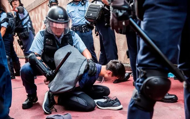 Police detain a man after fights broke out inside a shopping mall between pro-China supporters and anti-government protesters in the Kowloon Bay district of Hong Kong on September 14, 2019. Millions of people have taken part in demonstrations over the last three months which have morphed into calls for democracy and complaints against the erosion of freedoms under Beijing's rule. (Photo by Isaac Lawrence/AFP Photo)