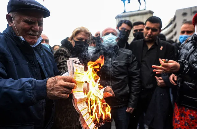 People burn their electricity bills as a protest against high energy prices in on February 9, 2022, as temperatures plunged well below freezing in Ankara and energy prices soared. Energy prices in Turkey and other countries have soared in the past year due to recovering demand and geopolitical tensions. But Turks have also seen their overall purchasing power dwindle dramatically amid a currency crisis and two-decade high inflation that reached almost 50 percent last month. (Photo by Adem Altan/AFP Photo)