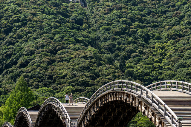 Visitors walk on the Kintaikyo Bridge, a historical wooden bridge built in 1673 in Iwakuni city of Yamaguchi Prefecture on June 10, 2024. (Photo by Philip Fong/AFP Photo)