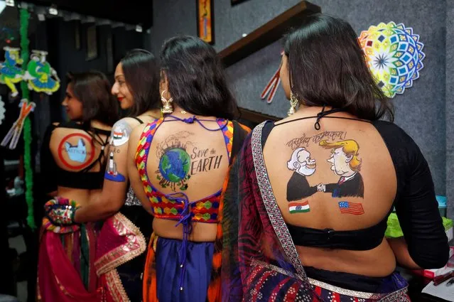 Women pose after they got body paint tattoos sketched on their backs in preparations for the upcoming Navratri, a festival when devotees worship the Hindu goddess Durga in Ahmedabad, India, September 24, 2019. (Photo by Amit Dave/Reuters)