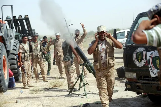 Members of Iraq's Shi'ite paramilitaries launch a mortar towards Islamic State militants on the outskirts of the city of Falluja, in the province of Anbar, Iraq July 12, 2015. (Photo by Reuters/Stringer)