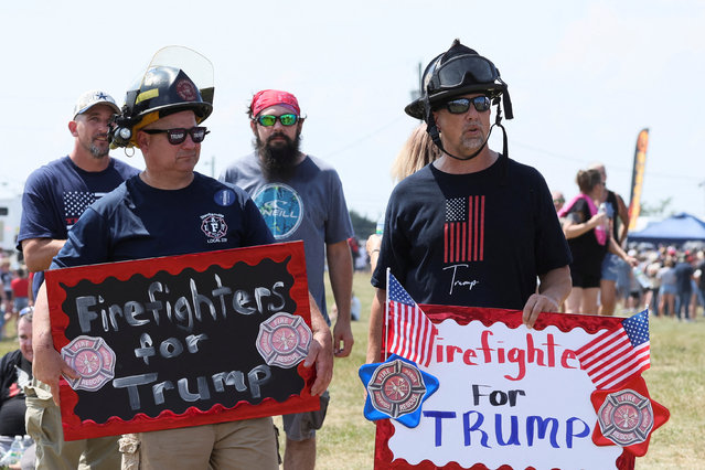 Firefighters hold signs as they attend a campaign rally for Republican presidential candidate and former President Donald Trump, in Butler, Pennsylvania, on July 13, 2024. (Photo by Brendan McDermid/Reuters)