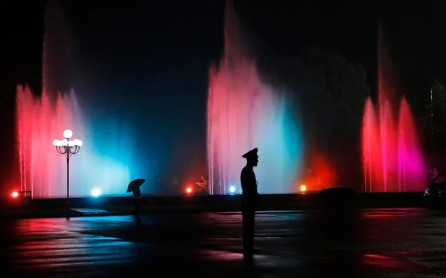 A soldier stands guard against a water fountain after a mass game performance of “The Land of the People” at the May Day Stadium in Pyongyang, North Korea, Tuesday, July 16, 2019. (Photo by Vincent Yu/AP Photo)