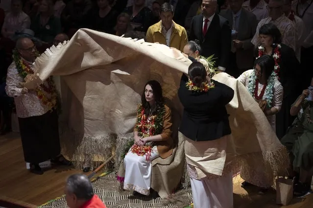 New Zealand Prime Minister Jacinda Ardern, center, is covered during a ceremony in Auckland, Sunday, August 1, 2021, to formally apologize for a racially charged part of the nation's history known as the Dawn Raids. The Dawn Raids are known as the time when the Pasifika people were targeted for deportation in the mid-1970s during aggressive home raids by authorities to find, convict and deport visa overstayers. (Photo by Brett Phibbs/New Zealand Herald via AP Photo)
