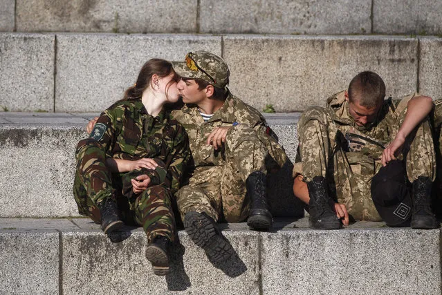 Two members and supporters of Right Sector political party kiss as they attend a mass meeting on Independence Square in Kiev, Ukraine, 21 July 2015. About 2,000 people attended a mass anti-government rally entitled “Go away government of traitors”, according to local reports. (Photo by Roman Pilipey/EPA)