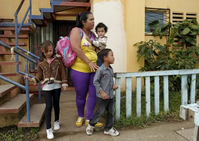 Hazel Castillo leaves her home with her three children to an aerobics class in Los Guidos de Desamparados July 23, 2015. (Photo by Juan Carlos Ulate/Reuters)