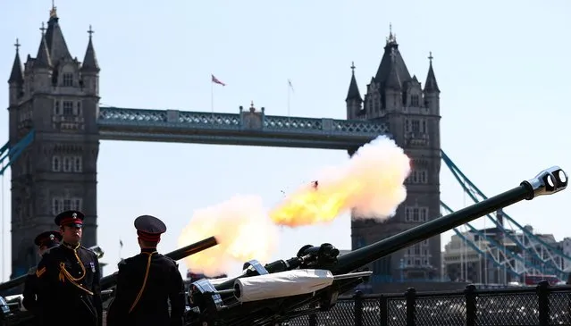 Members of the Honourable Artillery Company stand guard during the fire of the 62 Gun Royal Salute for the Queen's Birthday, from Tower Wharf, by Tower Bridge, in central London, April 21, 2022. The Gun salutes marks Queen Elizabeth II's 96th birthday, although the monarch herself was expected to mark the occasion with little fanfare after a troubled year hit by health concerns. (Photo by Adrian Dennis/AFP Photo)