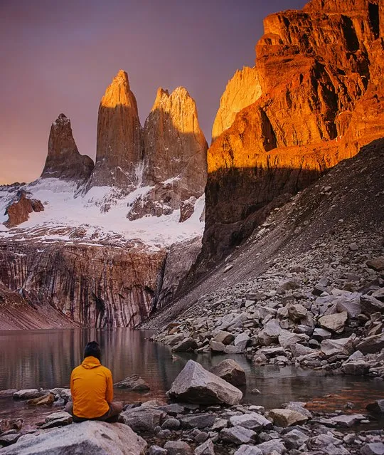 “Torres Del Paine”. Lone hiker in an orange jacket watching the sunrise in front of Mirador Torres in Torres Del Paine National Park in Patagonia. Photo location: Torres Del Paine, Chile, Patagonia, South America. (Photo and caption by Michael Marquand/National Geographic Photo Contest)