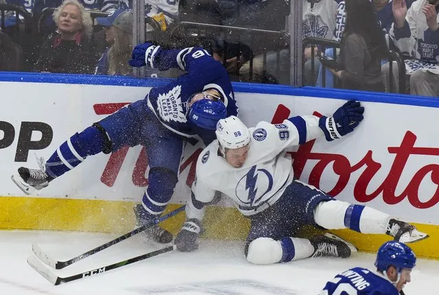 Toronto Maple Leafs forward Mitchell Marner (16) gets hit by Tampa Bay Lightning defenseman Mikhail Sergachev (98) during the second period of Game 2 of an NHL hockey Stanley Cup playoffs first-round series Wednesday, May 4, 2022, in Toronto. (Photo by Nathan Denette/The Canadian Press via AP Photo)