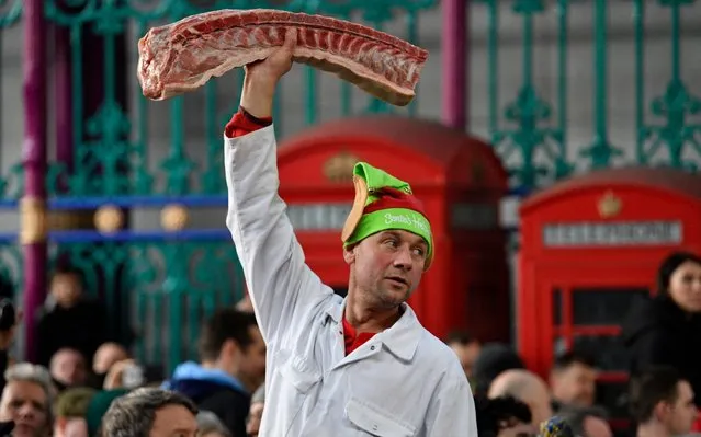 Shoppers bid for cuts of meat during a Christmas Eve auction in Smithfield market in London, Britain December 24, 2019. Meat produce is traditional sold at bargain prices on Christmas Eve in Smithfields, the largest wholesale meat market in the UK and one of the largest of its kind in Europe. (Photo by Neil Hall/EPA/EFE/Rex Features/Shutterstock)