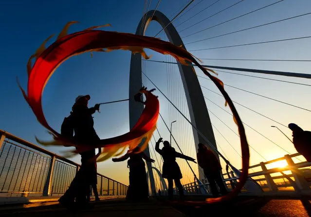 People perform a dragon dance to mark the New Year on Shougang Bridge in Beijing, China on January 1, 2020. (Photo by Reuters/China Daily)