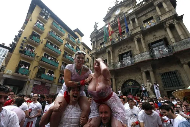 Revellers celebrate moments before the rocket fire or “Txupinazo” marks the start of the Festival of San Fermin (or Sanfermines) at Consistorio square in Pamplona, Spain, 06 July 2014. (Photo by Javier Lizin/EFE)