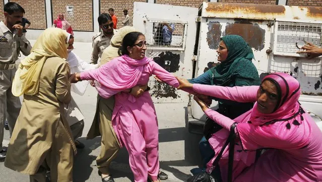 Indian police officers try to detain an Employee of the Social Welfare department during a protest in Srinagar, the summer capital of Indian Kashmir, 15 June 2016. Employees of Social Welfare department protested outside the Legislative Assembly during its session. They were demanding regularization of their jobs and an increase in their monthly wages. (Photo by Farooq Khan/EPA)