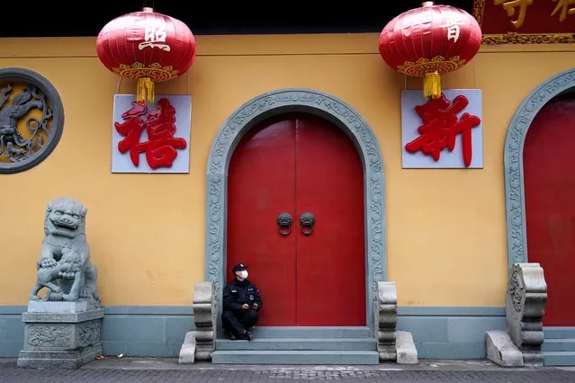 A security guard sits at the entrance of a closed temple in Shanghai, China on January 24, 2020. (Photo by Aly Song/Reuters)