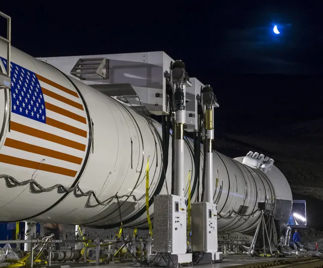 The moon rises ahead of the second and final qualification motor (QM-2) test for the Space Launch System's booster, Tuesday, June 28, 2016, at Orbital ATK Propulsion Systems test facilities in Promontory, Utah. During the Space Launch System flight the boosters will provide more than 75 percent of the thrust needed to escape the gravitational pull of the Earth, the first step on NASA's Journey to Mars. (Photo by Bill Ingalls/NASA via AP Photo)