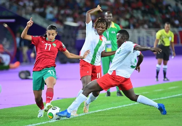 Hanane Ait El Haj (L) of Morocco, in action against Balkissa Sawadogo, and Assanato Nako, of Burkina Faso, during the soccer match of the Women's Africa Cup of Nations between Morocco and Burkina Faso, in Rabat, Morocco, 02 July 2022. (Photo by Jalal Morchidi/EPA/EFE)