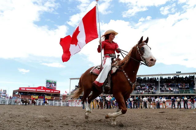 A Stampede ranch girl carries the Canadian flag during the national anthem at the Calgary Stampede rodeo in Calgary, Alberta, Canada July 8, 2016. (Photo by Todd Korol/Reuters)