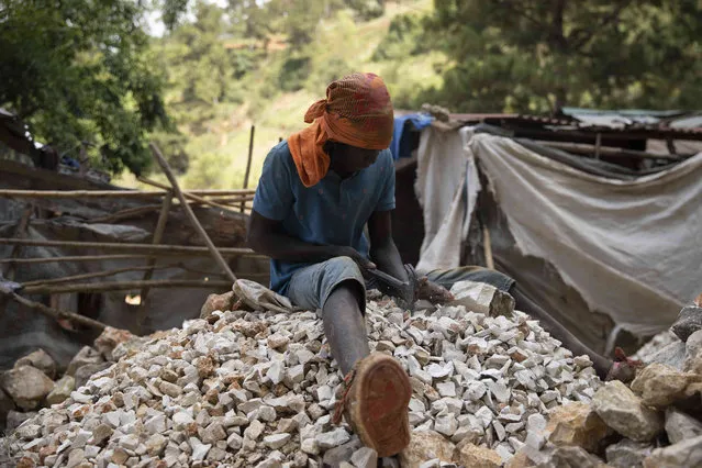 A man breaks rocks into gravel for construction sites in the Kenscoff neighborhood of Port-au-Prince, Haiti, Friday, June 24, 2022. (Photo by Odelyn Joshep/AP Photo)