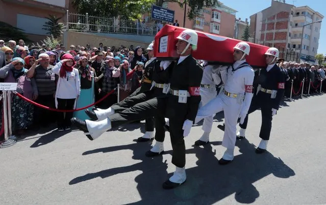 Parents and other family members salute in military-style as honour guard carry the coffin of Eyup Oksuz, a 21-year-old Turkish soldier killed by Kurdish rebels in eastern city of Van on Saturday, during his funeral in Ankara, Turkey, Monday, July 11, 2016. In a separate attack, a vehicle laden with explosives hit an army outpost in Mardin province in southeastern Turkey on Saturday, killing two soldiers and a civilian woman, officials said. (Photo by Burhan Ozbilici/AP Photo)