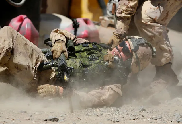 A Canadian soldier is helped to safety as a platoon from the Royal 22nd Regiment train during a non-combative extraction operation in a simulated village as part of Rim of the Pacific (RIMPAC) 2016 exercise held at Camp Pendleton, California United States, July 11, 2016. (Photo by Mike Blake/Reuters)
