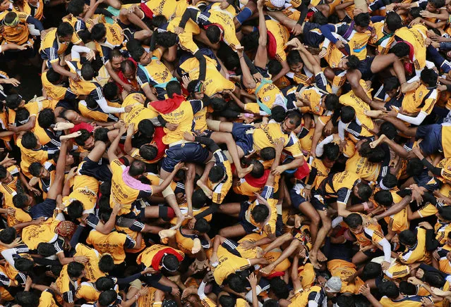 People fall down as they try to form a human pyramid during celebrations to mark “Janmashtami” in Mumbai, India, Monday, August 18, 2014. (Photo by Rafiq Maqbool/AP Photo)