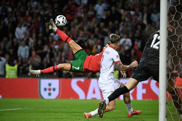Portugal's forward Cristiano Ronaldo (L) scores their fifth goal during the UEFA Nations League, League A, Group 1 football match between Portugal and Poland at the Dragao stadium in Porto, on November 15, 2024. (Photo by Miguel Riopa/AFP Photo)