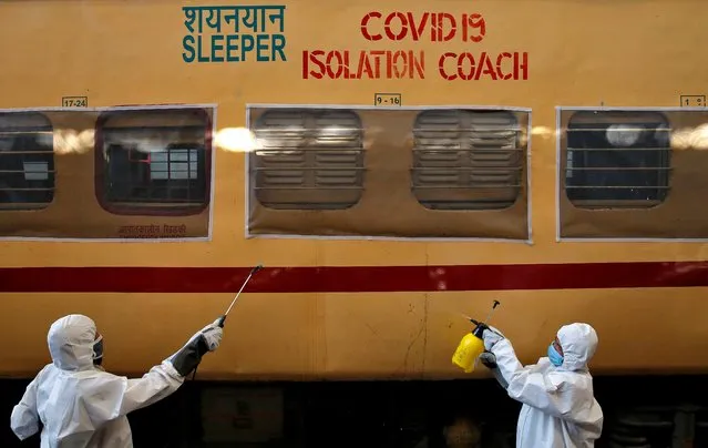 Workers wearing protective suits disinfect the exterior of a passenger train after it was converted into an isolation facility amid concerns about the spread of coronavirus disease (COVID-19), on the outskirts of Kolkata, India, April 6, 2020. (Photo by Rupak De Chowdhuri/Reuters)