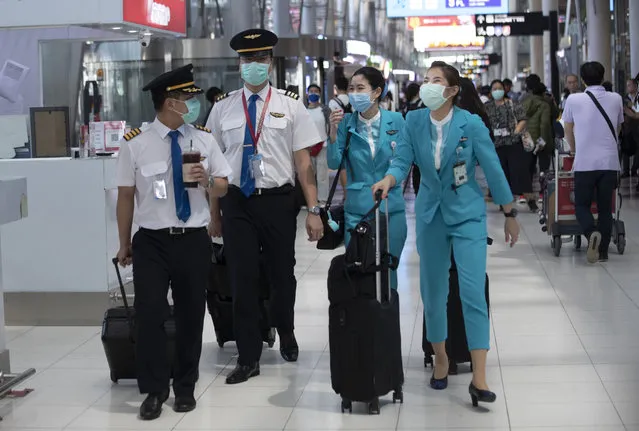 Flight crew wear protective masks as they arrive at the Suvarnabhumi Airport in Bangkok, Thailand, Wednesday, March 2, 2020. (Photo by Sakchai Lalit/AP Photo)