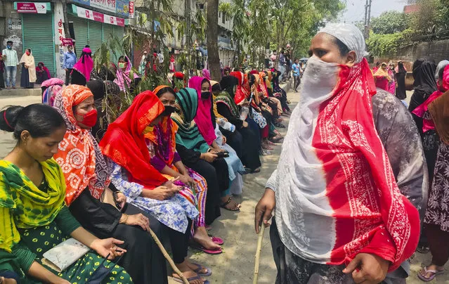 Bangladeshi garment workers block a road demanding their unpaid wages during a protest in Dhaka, Bangladesh, Thursday, April 16, 2020. Hundreds of Bangladeshi workers who produce garments for global brands protested in Dhaka and blocked a highway outside the capital on Thursday to demand unpaid wages during a nationwide lockdown that has forced most factories to suspend operations. (Photo by Al-emrun Garjon/AP Photo)